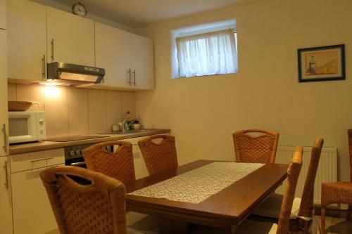a kitchen with a table and chairs and a microwave at Ferienwohnung Waldschlößchen in Wattenbach