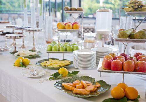 a white table with plates of fruit and desserts at La Medusa Hotel - Dimora di Charme in Castellammare di Stabia