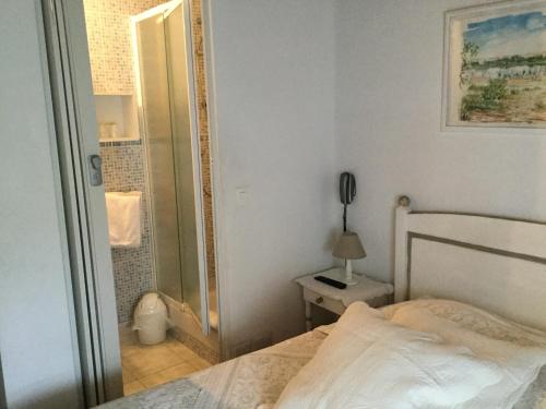 a bedroom with a white bed and a mirror at Hotel Le Méditérranée in Saintes-Maries-de-la-Mer