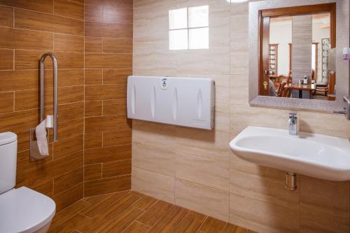 uma casa de banho com um lavatório, um WC e um espelho. em Pension Restaurante Cantábrico em Cariño