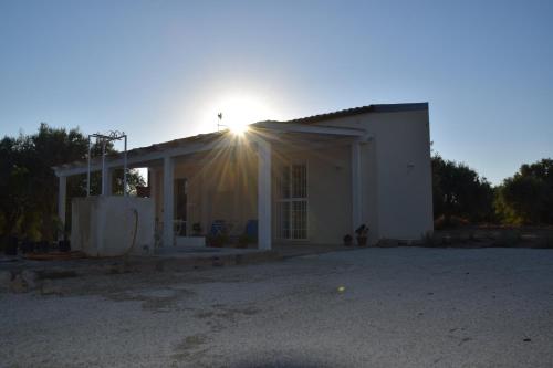a house with the sun shining on the roof at Tempo Di Vendicari in La Banca