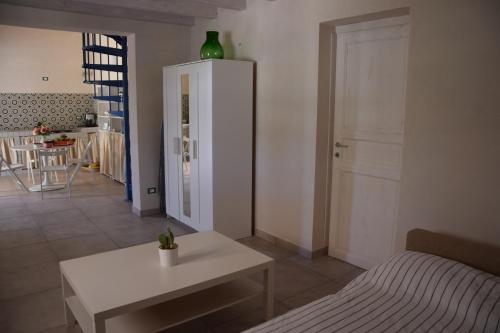 a living room with a bed and a white table at Tempo Di Vendicari in La Banca