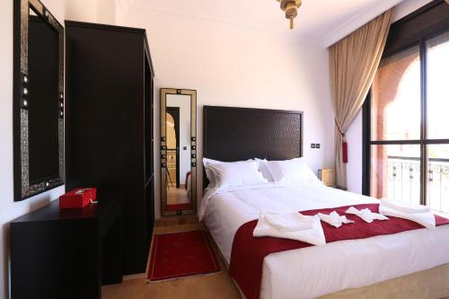 ein Schlafzimmer mit einem großen weißen Bett und einem Spiegel in der Unterkunft Villa Nelya in Marrakesch