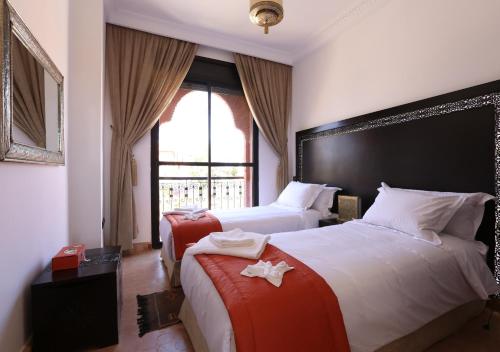 een hotelkamer met twee bedden en een raam bij Villa Nelya in Marrakesh