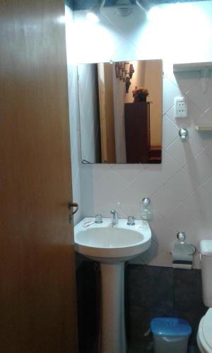 a bathroom with a sink and a mirror and a toilet at La Daimalé Apart in Colón