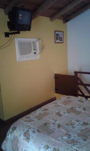 a bedroom with a bed and a tv on the wall at La Daimalé Apart in Colón