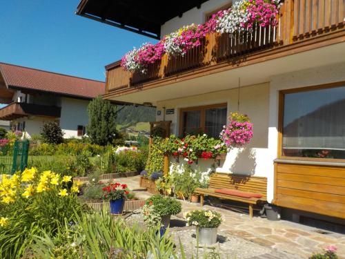 um jardim com flores e um banco em frente a um edifício em Ferienwohnung Salchegger em Flachau