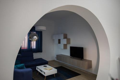 Karma Resort في فينيتيكو: غرفة معيشة مع أريكة زرقاء وتلفزيون