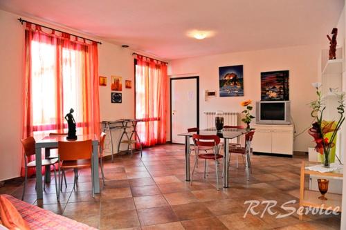 ein Wohnzimmer mit einem Tisch und Stühlen sowie eine Küche in der Unterkunft Miluna B&B in Nocera Umbra