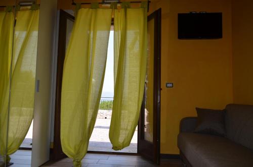 a living room with yellow curtains and a sliding glass door at Agriturismo Monte Cesima in Sesto Campano