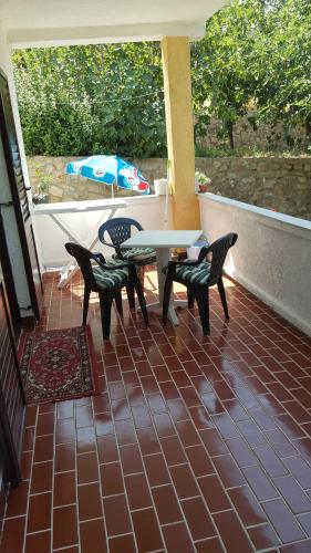 a patio with a table and chairs and an umbrella at Vera Apartment in Rab