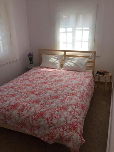 a bedroom with a bed with a red blanket and a window at Duplex Casco Histórico in Pontevedra