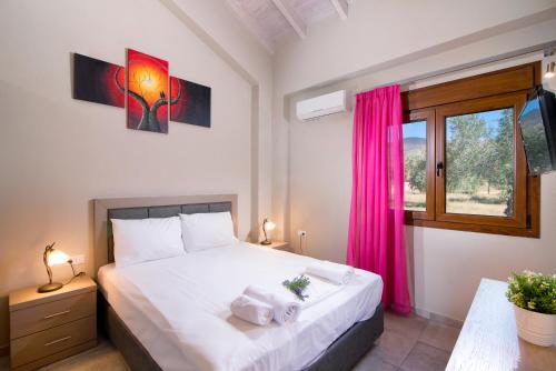 a bedroom with a bed and a window with pink curtains at Olive Land Villas in Limenaria