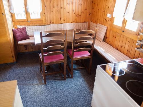 a dining room with a table and chairs and a couch at Gruppenhaus im Walliser Alpstyle in Rosswald