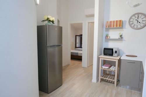 a kitchen with a refrigerator and a clock on the wall at Le Querce Apartments in Ronchi