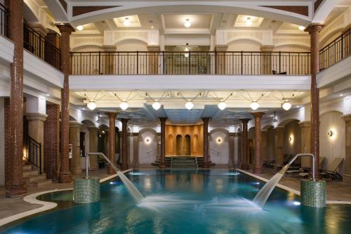 a pool in a building with water fountains at Andrássy Kúria & Spa in Tarcal