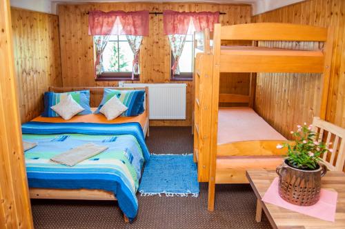 a bedroom with two bunk beds and a table at Pension Alex in Benecko