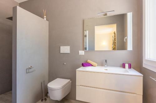 a bathroom with a sink and a toilet and a mirror at Villa Stella Cadente in Serranova