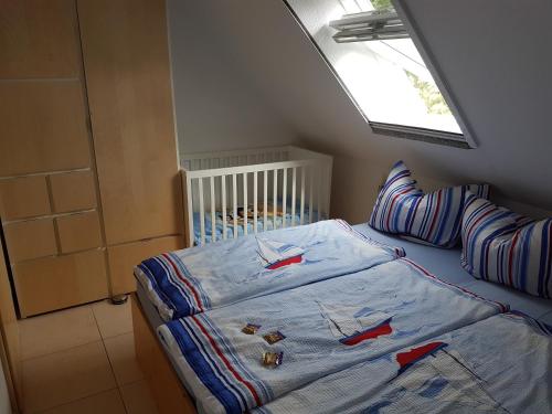 ein kleines Schlafzimmer mit einem Bett und einem Fenster in der Unterkunft Haus Mareén in Graal-Müritz