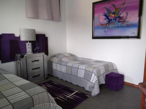 a bedroom with a bed and a dresser and a picture at Charmant Horizon in La Turbie