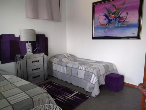 ラ・テュルビーにあるCharmant Horizonのベッドルーム1室(ベッド1台、ドレッサー、写真付)