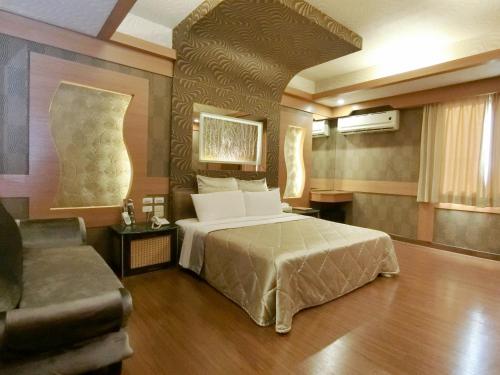 pokój hotelowy z łóżkiem i kanapą w obiekcie Wind Coast Motel w mieście Xinzhu