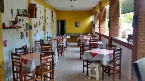 a dining room with tables and chairs in a restaurant at Sonhos Meu Pousada in Boracéia