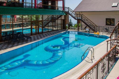a large swimming pool with a spiral staircase next to a building at Veseliy Hotey in Gurzuf