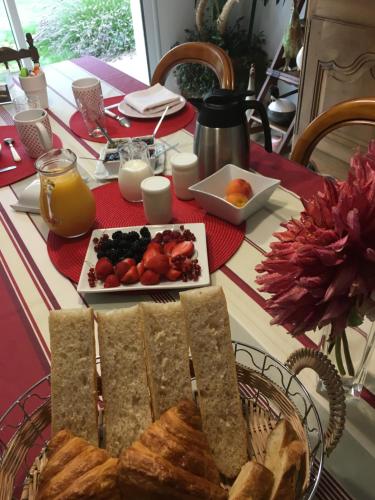 einen Tisch mit einem Teller Brot und einem Obstteller in der Unterkunft Villa Magdanic in Moëlan-sur-Mer