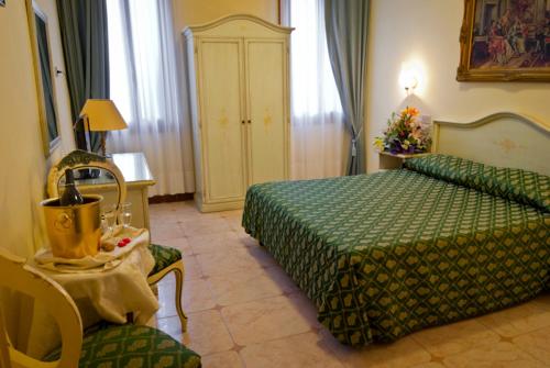 a hotel room with a green bed and a chair at Hotel Florida in Venice