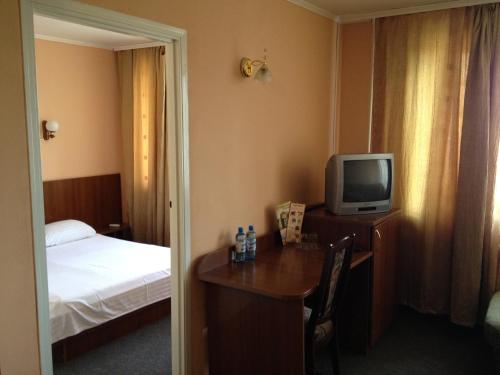 a hotel room with a bed and a television at Tsentralniy Hotel in Khmelʼnytsʼkyy