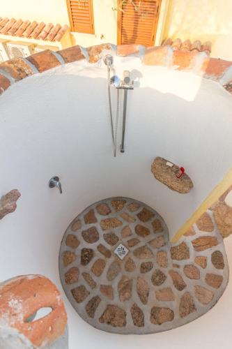 a bathtub with a stone floor with a sink at Molti Mari B&B Resort in Olbia