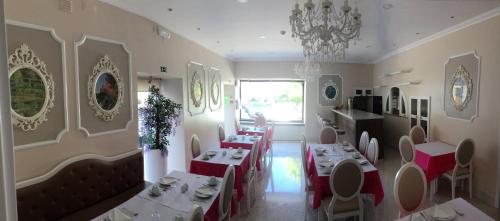 a restaurant with tables and chairs and a chandelier at The Capital Boutique B&B in Peniche