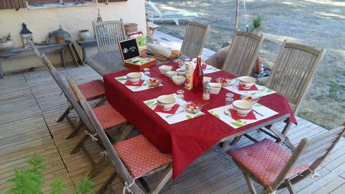 une table avec un tissu de table rouge sur une terrasse dans l'établissement Clos de l'Artuby, à Valderoure