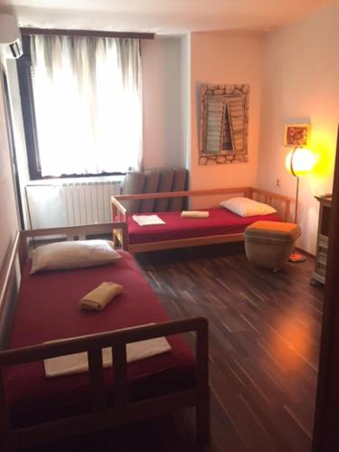 a living room with two beds and a window at Rooms Ana in Kotor