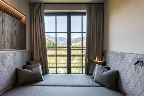 a bedroom with a bed and a large window at Hotel Seehof Nature Retreat in Naz-Sciaves