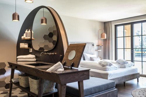 a hotel room with a sink and a mirror at Hotel Seehof Nature Retreat in Naz-Sciaves