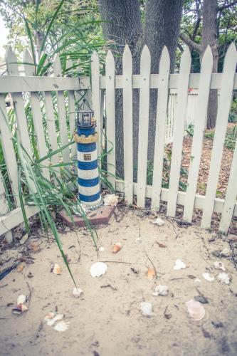 a white picket fence with a lighthouse in the sand at Silver Heart Inn & Cottages in Independence