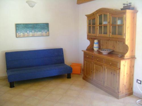 ノート・マリーナにあるVilla Flaviaの木製キャビネット付きの客室で、青いソファが備わります。