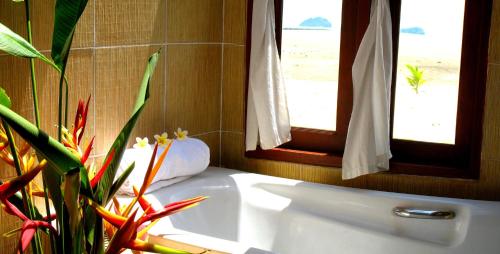a bathroom with a white tub and two windows at Phangka Paradise Resort in Taling Ngam Beach