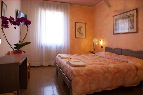 a bedroom with a bed and a window with purple flowers at Hotel STELLA D'ORO in Spilimbergo