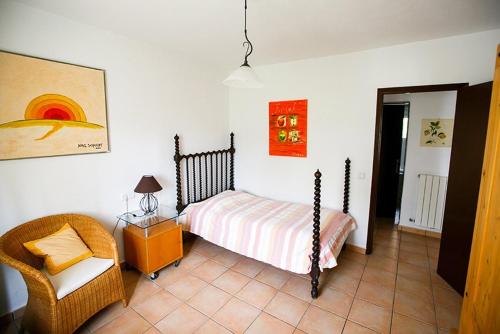 1 dormitorio con 1 cama y 1 silla en Casa Heidi, en Cala Santanyi