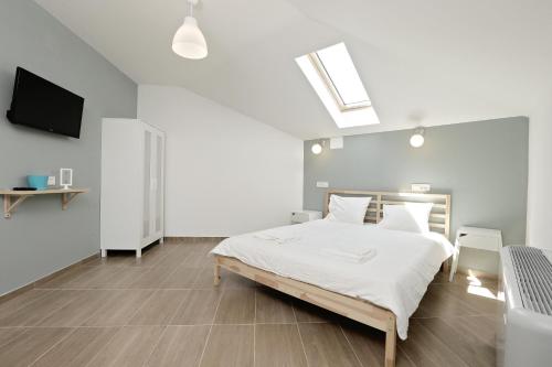 a white bedroom with a bed and a television at Thermal Family Resort in Baile Felix
