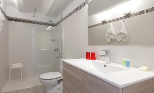 a bathroom with a sink and a toilet and a shower at Apartamentos MR La Raconà in Denia