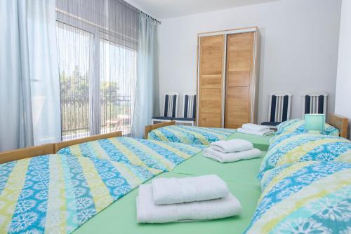 a bedroom with two beds with towels on them at Luxury Rooms Ivana in Kaštela