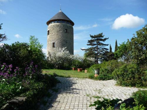 a lighthouse in the middle of a garden with a path at Au Moulin Géant in Rochefort-sur-Loire