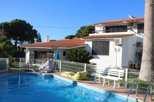 a swimming pool in front of a house at Casa Teresinha in Sesimbra