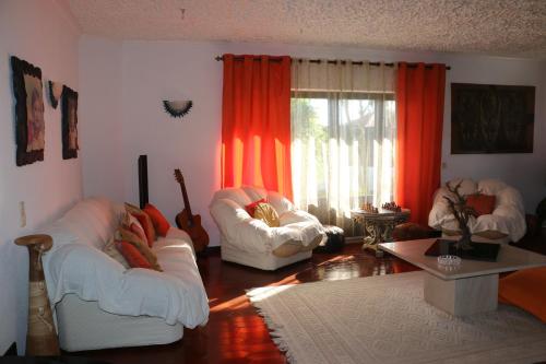 a living room with two white couches and a window at Casa Teresinha in Sesimbra