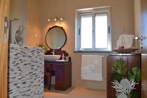 a bathroom with a sink and a mirror at Cantinho da Bela Vista in Porto Judeu
