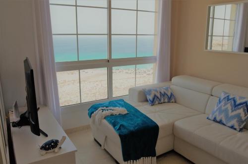 een woonkamer met een witte bank en een raam bij Apartamento Vista Esmeralda en PLAYA PARAISO in Costa Calma